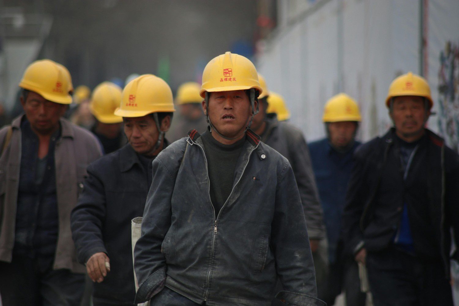 a group of men wearing yellow hard hats