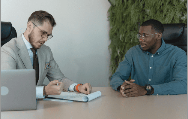 a man looking at a paper with a pen