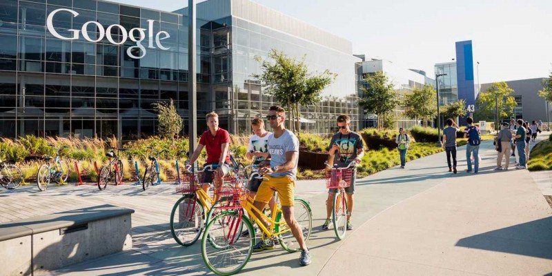 A Group Of People Riding Bicycles Outside A Building