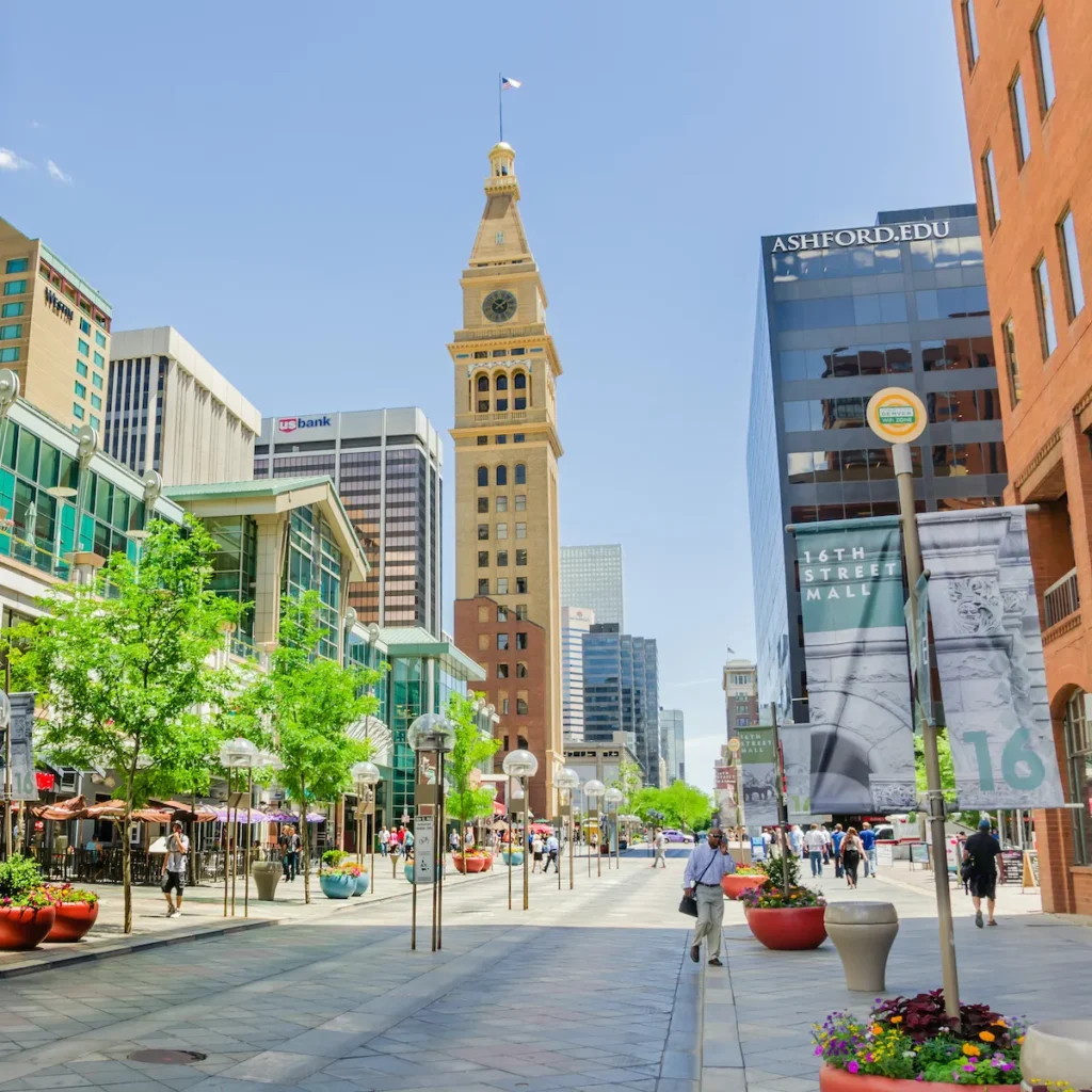 A City Street With Tall Buildings And People Walking