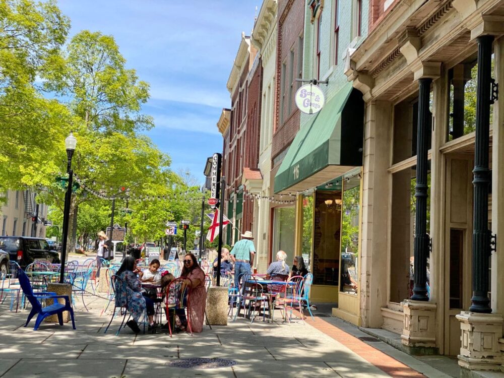 people sitting at tables outside a restaurant